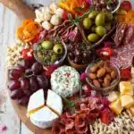 Planche apéritive festive pour la fête des mères avec fromages et charcuterie.