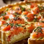 Quiche au saumon et Boursin fraîchement cuite, servie en tranches appétissantes.